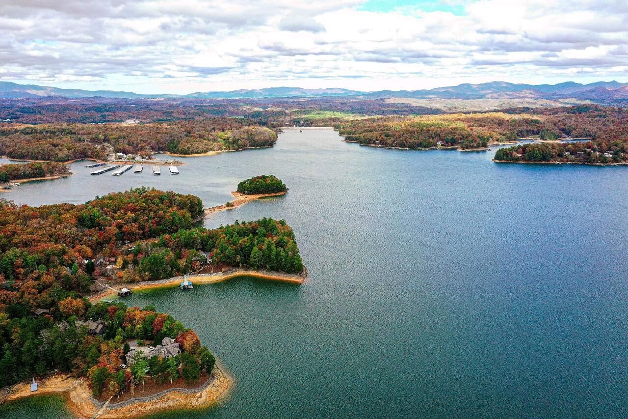 An aerial view of a lake with multiple islands, docks, and surrounding forested areas.
