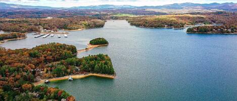 An aerial view of a lake with multiple islands, docks, and surrounding forested areas.