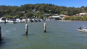 Un port de plaisance où sont amarrés des bateaux, entouré d’arbres et de maisons.