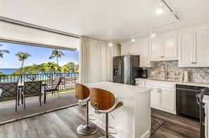 Enjoy a convenient workspace and ocean views from this kitchen with a sleek island and large window.