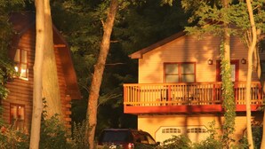 A cabin with a balcony, surrounded by trees. - Luxury lakefront apartment and private pool! Pool open Memorial Day - Labor Day. (Seneca Falls)