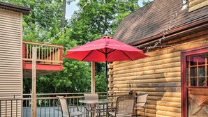 A log cabin with a balcony, outdoor seating, and a red umbrella. - Luxury lakefront apartment and private pool! Pool open Memorial Day - Labor Day. (Seneca Falls)
