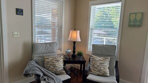 Un coin salon confortable avec deux fauteuils, une petite table avec une lampe et des coussins décoratifs.