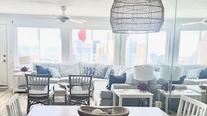 Una sala de estar moderna con comedor, ventanas amplias y vista a la ciudad.