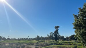 A golf course with a clear sky and sunlight.