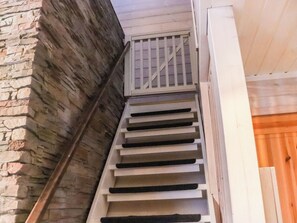 Un escalier avec une rampe en métal menant à une porte en bois.