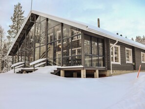 Ein modernes Gebäude mit großen Glasfenstern, einem geneigten Dach und einer Treppe, die zum Eingang führt.