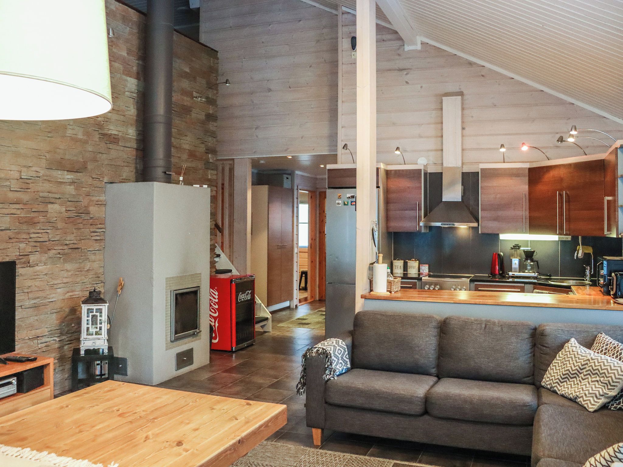 Una cocina moderna con una isla central, estufa integrada y un área de comedor con mesa de madera.