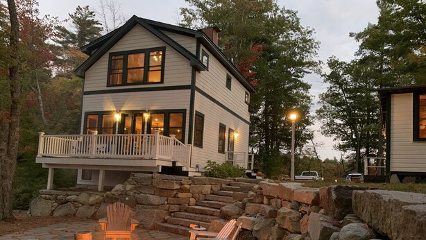 A two-story house with a stone staircase leading to a deck. - LAKESIDE RETREAT!  A HIDDEN GEM!!! (Ossipee)