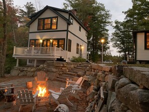 A two-story house with a stone staircase leading to a deck. - LAKESIDE RETREAT!  A HIDDEN GEM!!! (Ossipee)