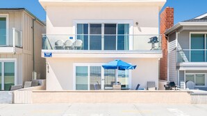 A two-story building with a balcony, outdoor seating, and a sign indicating 'Beachview Rentals.' - Spectacular Ocean Views at Affordable Prices | Super Central | Walk to Everything! (Newport Beach)