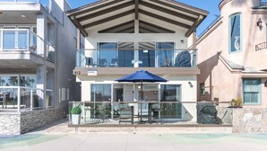 A two-story building with a balcony and outdoor seating area.