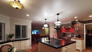 A modern kitchen with a central island, pendant lighting, and a brick backsplash. - 2800sqft Luxurious home with bay view private pool near SF & NAPA (Vallejo)