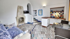 Una sala de estar moderna con chimenea, una escalera, un comedor y una estantería.