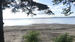 A beach with a bench and a tree in the foreground. - Sunset on the Ottawa "Cottage"- shallow, silky sandy beach w/ 78-84 F warm water (Pembroke)