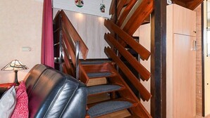 Eine Treppe mit Holzboden und ein Sofa aus Leder mit Kissen.