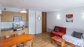 A compact living space with a kitchen, dining area, and seating area. - Studio cabin, pets allowed - 4 guests (La Mongie)