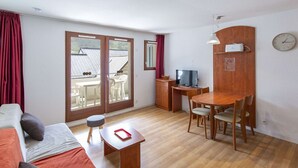 A compact room with a bed, a small table, a TV, and a dining area. - Studio cabin, pets allowed - 4 guests (La Mongie)