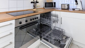 Une cuisine moderne avec des armoires blanches, des appareils en acier inoxydable et un comptoir en bois.