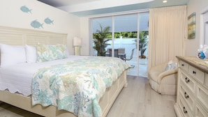 A bedroom with a bed, a dresser, a chair, a window, and a view of the outdoors. - 801 Mariners Club - Luxury Key Largo Townhouse (Key Largo)