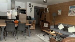 Un espacio habitable moderno con comedor, sofá y mesa de centro.