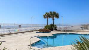 A pool area with a clear view of the beach and ocean. - Enjoy Modern Luxury Design in this Oceanfront, Corner Unit!  Stunning Ocean Views & Community Pool. (Folly Beach)