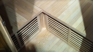 Une pièce dotée d’un plafond en pente, d’un plancher en bois et d’un coin où est installé un système de ventilation intégré.
