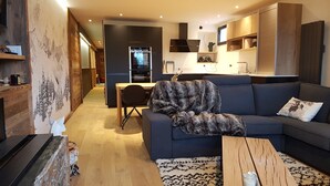 A modern living room with a dark sofa, a coffee table, and a patterned rug. - 80 m2, ski in / out center Alpe d'huez, luxury 8p 3bdrm 3bathroom 3 terraces with fireplace SPOT (ALPE D HUEZ)