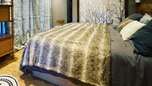 A modern bedroom with a large bed, a wooden headboard, a TV, and a wall-mounted lamp. - 80 m2, ski in / out center Alpe d'huez, luxury 8p 3bdrm 3bathroom 3 terraces with fireplace SPOT (ALPE D HUEZ)