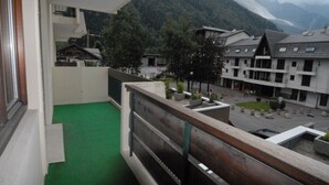 A balcony with a view of a mountain and traditional buildings.