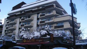 A multi-story building with balconies and a sign for a restaurant.
