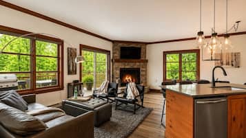 A spacious living area with a fireplace, a dining area, and a kitchen with a large island.