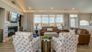 A living room with a fireplace, sofas, a coffee table, and a TV.