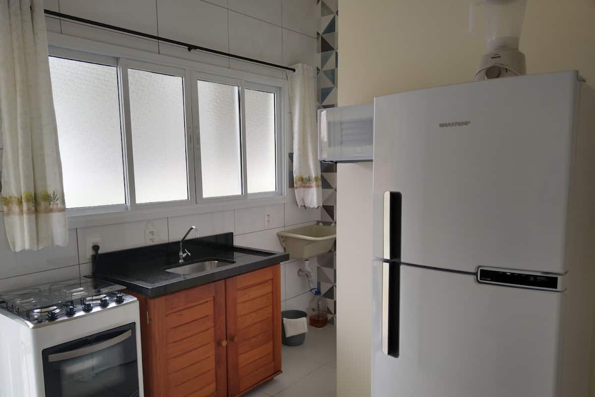 A kitchen with a stove, oven, sink, and a refrigerator.