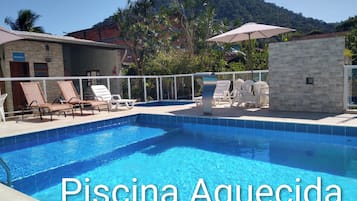 Alberca al aire libre, sombrillas en la alberca y camastros