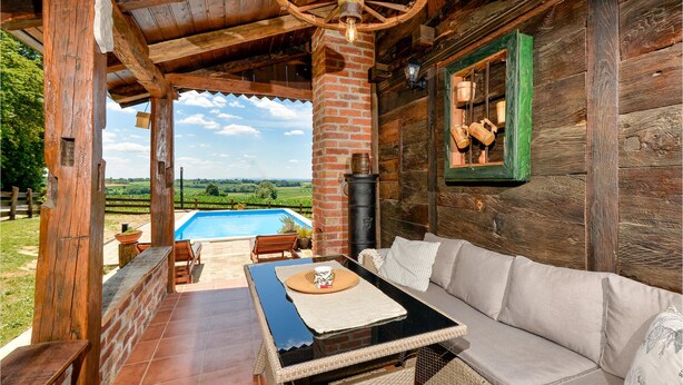 A rustic wooden cabin with a pool, outdoor seating, and a view of the countryside. - Lovely home in Starcevljani (Starcevljani)
