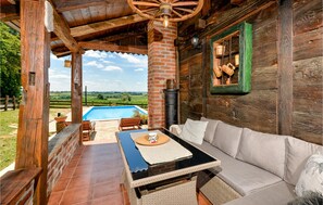Uma cabana rústica de madeira com piscina, área de estar externa e vista para o campo.
