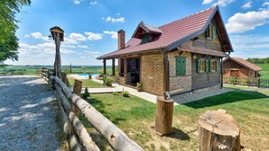 A rustic house with a brick exterior, a red-tiled roof, and a wooden porch. - Lovely home in Starcevljani (Starcevljani)