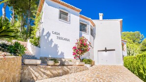 A white building with the sign "CASA TOSCANA" on the facade, a tiled entrance, and a stone pathway leading up to it.