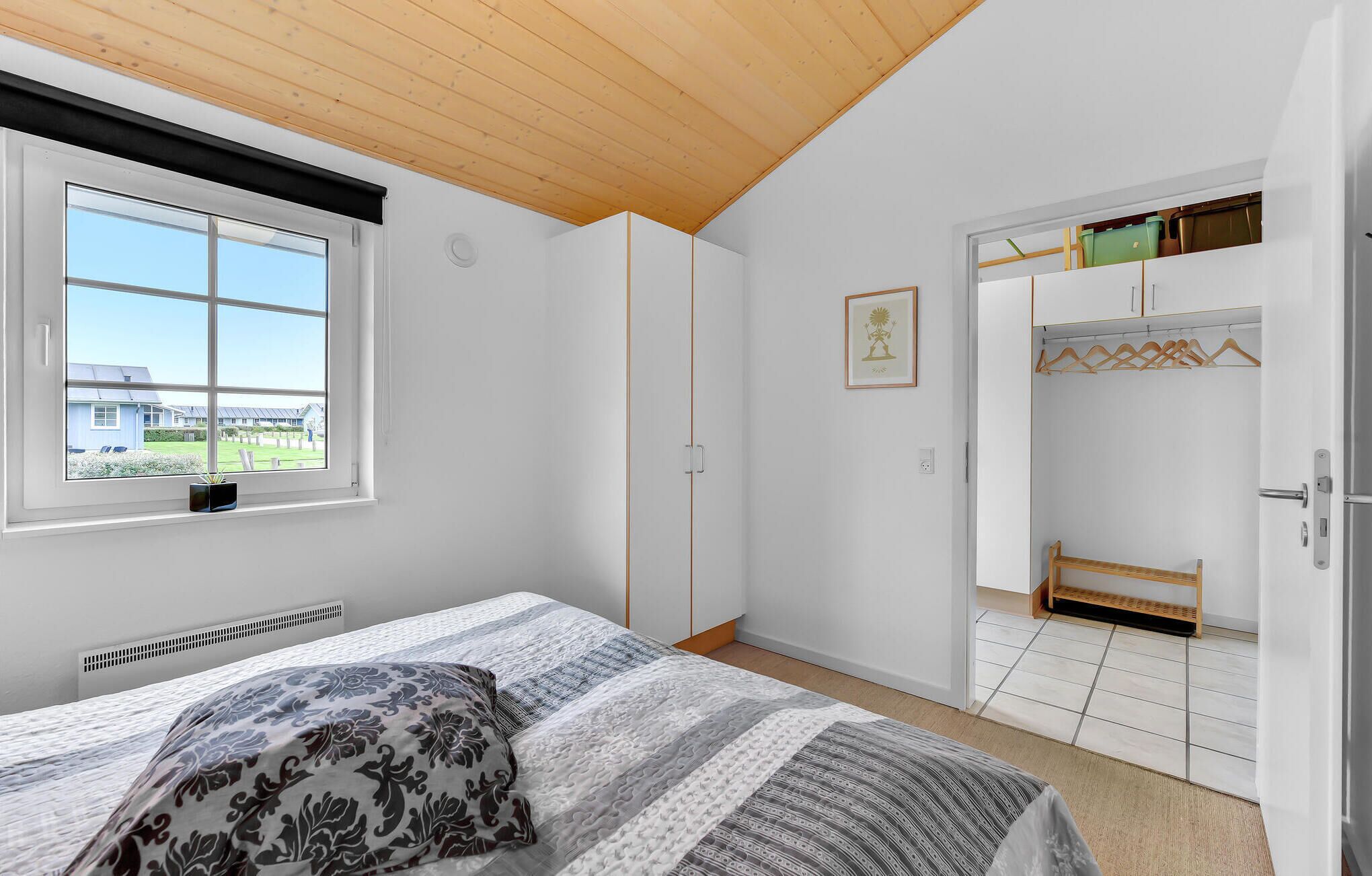 Une chambre à coucher avec un lit, une fenêtre, une armoire et un placard.