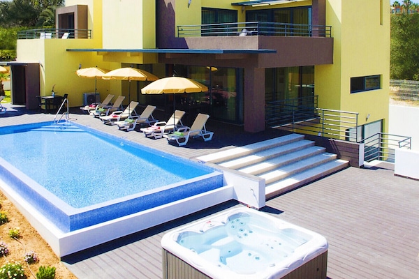 Een verwarmd zwembad en ligstoelen