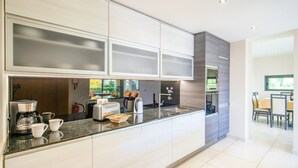 A modern kitchen with a built-in oven, a coffee maker, and a toaster. - Exclusive villa with jacuzzi and heatable pool (Armação de Pêra)