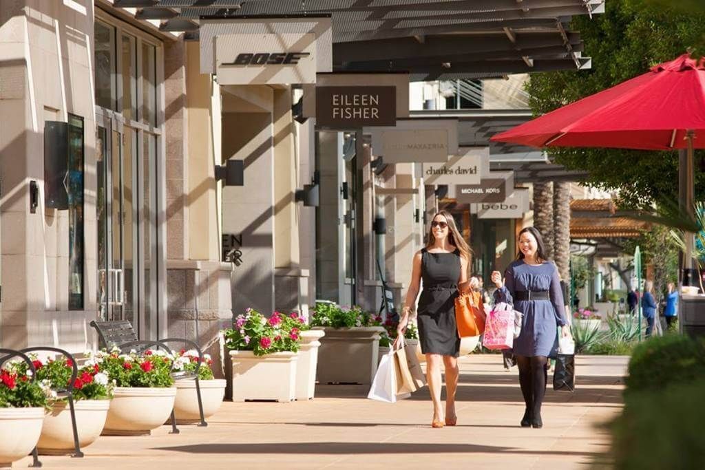 Una zona comercial con una tienda llamada Eileen Fisher y otra tienda llamada Charles & Darryl.