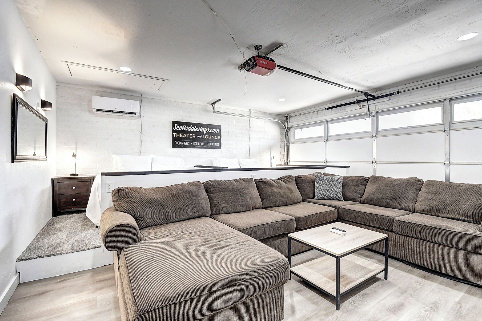 Una sala moderna con un sofá modular, una mesa de centro y un ventilador de techo.