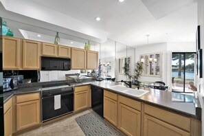 A modern kitchen with wooden cabinets, stainless steel appliances, and a large island. - Waterfront 1st Floor, Gated, 2 Bd,2Ba + Den, Family Friendly, Pet Friendly. (Scottsdale)