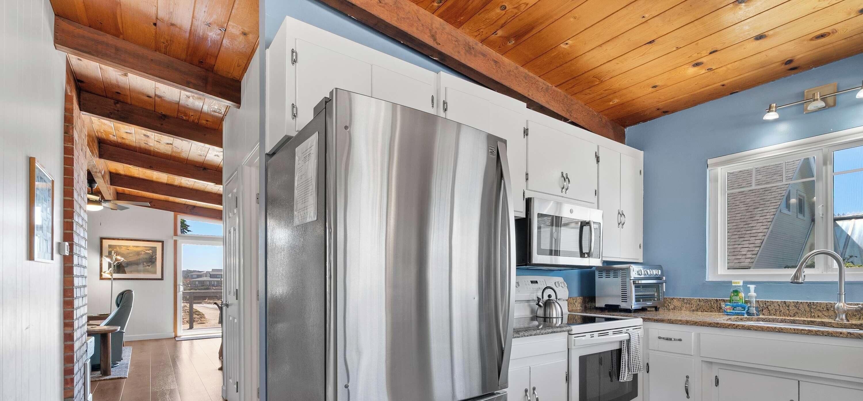 Una cocina moderna con electrodomésticos de acero inoxidable, encimera de granito y vistas a la ciudad.