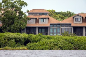 A two-story house with a large window and a balcony.