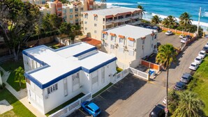 A coastal hotel with multiple buildings, a parking lot, and a view of the ocean. - Jobos Beach Apartment A-3 (Isabela)