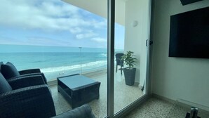 Uma varanda com vista para a praia e o oceano.