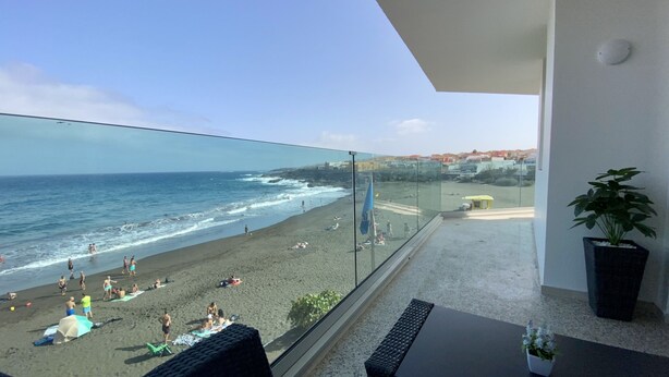 Varanda com vista para uma praia e o oceano.
